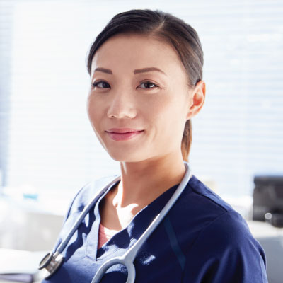 Nurse in blue scrubs smiling at camera