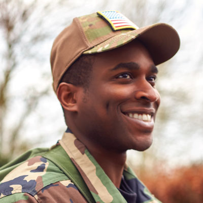 Solidier in fatigues smiling at something off camera